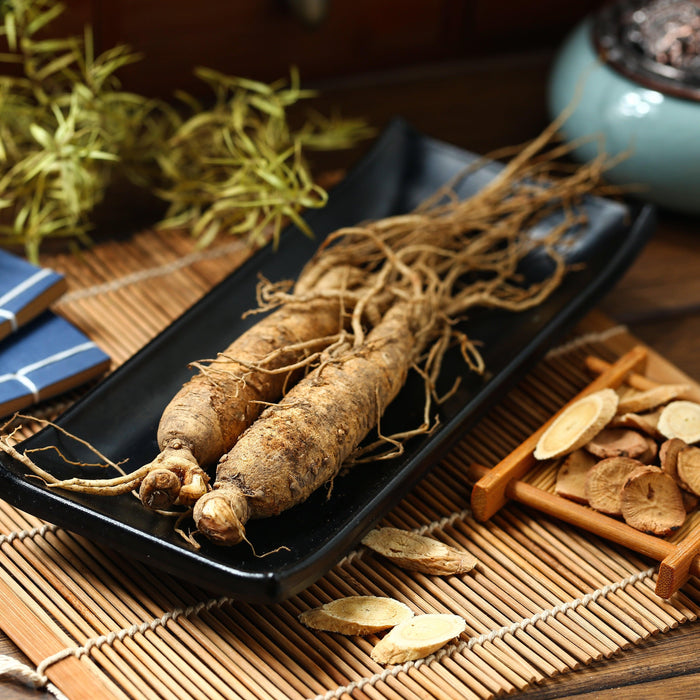 Wisconsin ginseng roots and dried slices on bamboo mat, natural non-GMO farm-grown quality